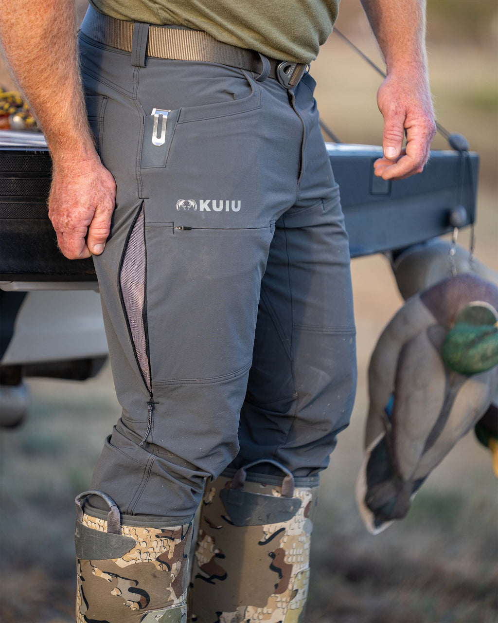 Hunter displaying zippered, mesh-lined hip vents on Reed Pant in Gunmetal Grey